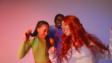 Studio-Shot-Of-Young-Gen-Z-Friends-Dancing-At-Club-Against-Pink-Background-1